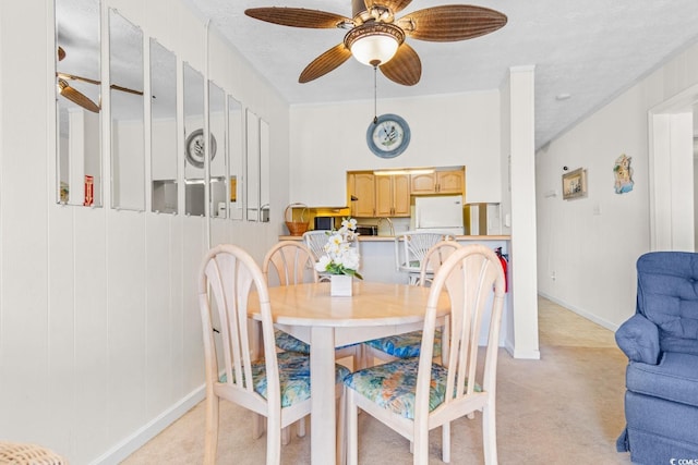 carpeted dining area with ceiling fan and a textured ceiling