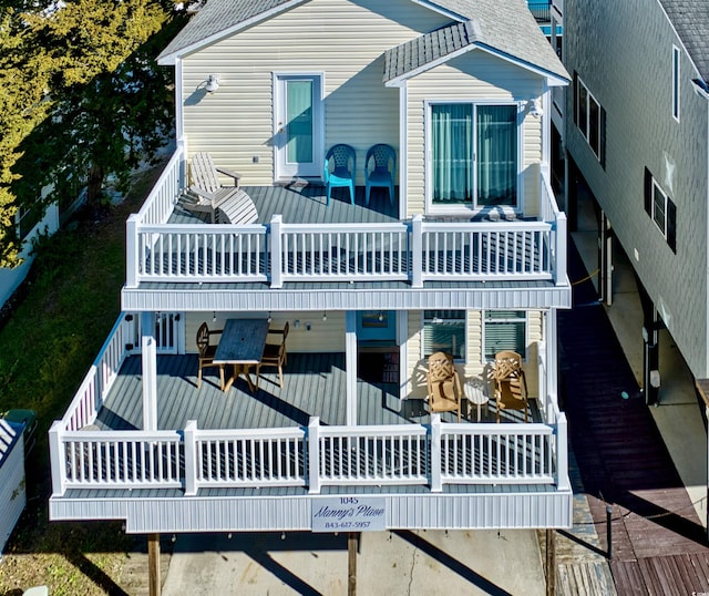 back of property featuring a balcony and a wooden deck