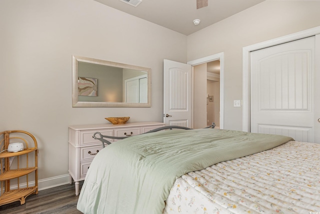 bedroom with dark hardwood / wood-style floors and a closet