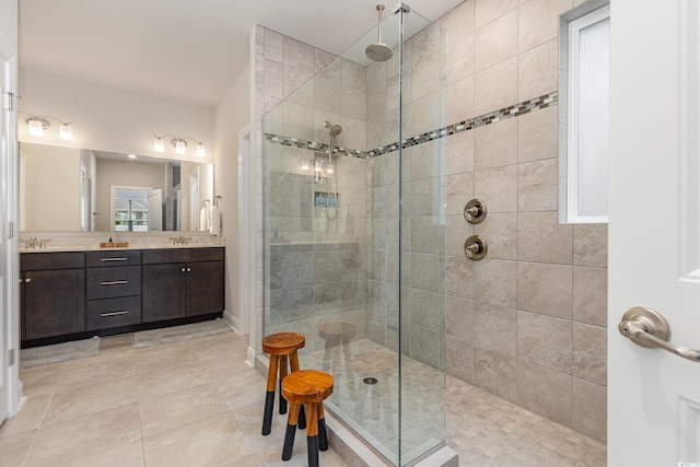 bathroom with tile patterned floors, vanity, and tiled shower