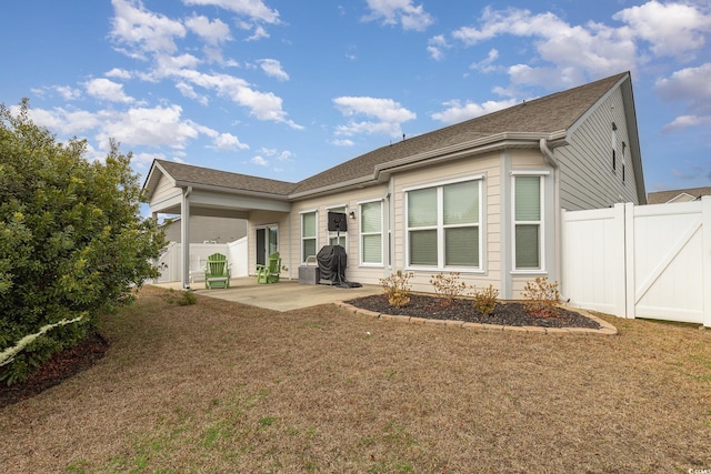 rear view of house featuring a lawn and a patio area