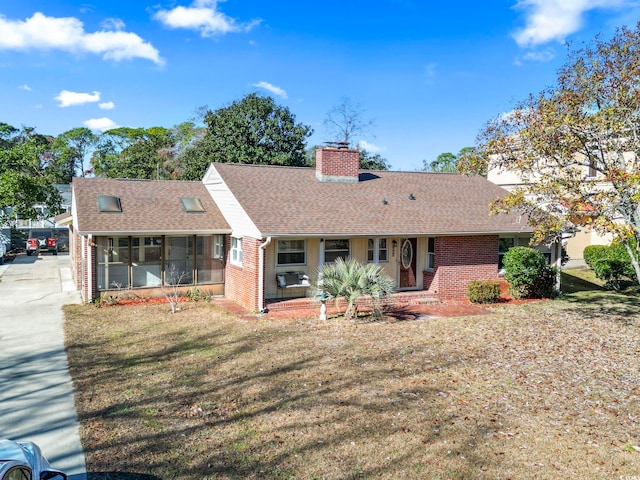 single story home featuring a sunroom and a front yard