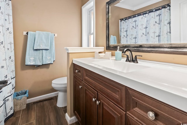 bathroom featuring crown molding, vanity, and toilet