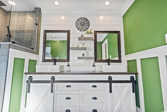 bathroom with vanity, ornamental molding, and tiled shower