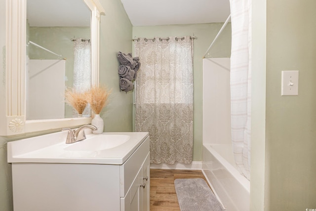 bathroom with hardwood / wood-style flooring, vanity, and shower / tub combo