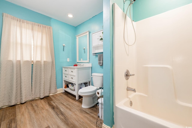 full bathroom featuring bathing tub / shower combination, hardwood / wood-style floors, vanity, and toilet