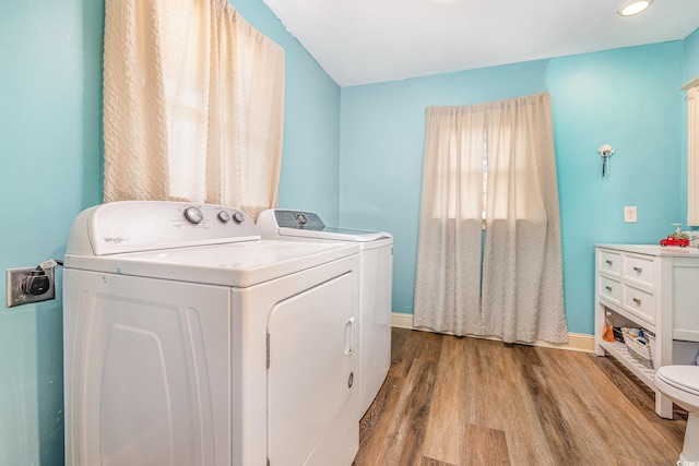 laundry room featuring separate washer and dryer and light hardwood / wood-style floors