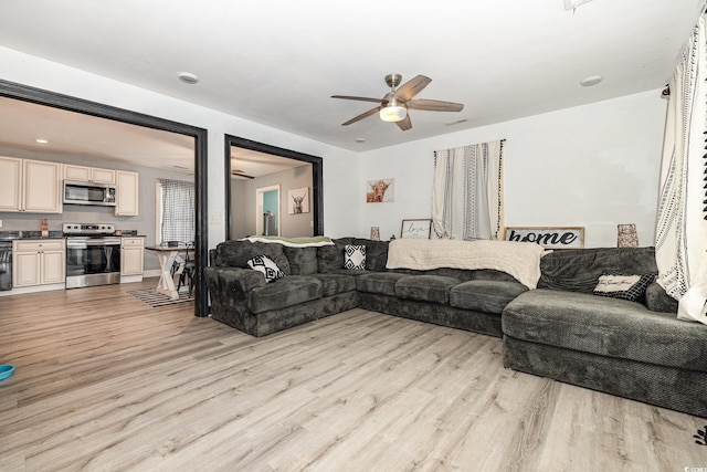 living room with light wood-type flooring and ceiling fan