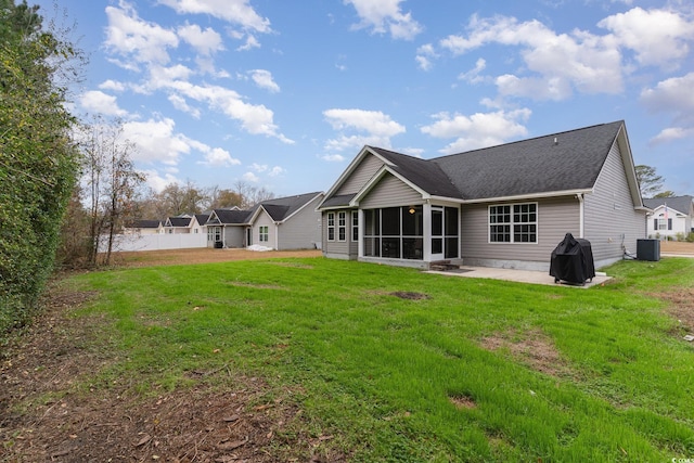 rear view of property with central air condition unit, a sunroom, a yard, and a patio