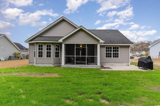 rear view of house with a patio, central AC unit, a lawn, and a sunroom