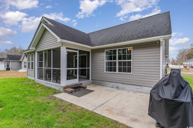 rear view of property featuring a lawn, a sunroom, and a patio area