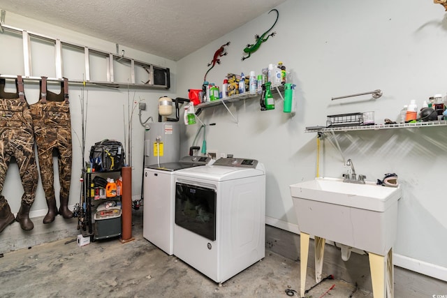 laundry area featuring a textured ceiling, electric water heater, and washing machine and clothes dryer