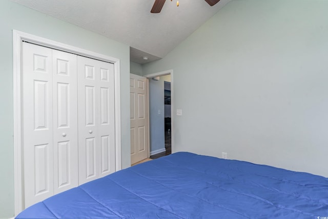 bedroom featuring a textured ceiling, a closet, ceiling fan, and lofted ceiling