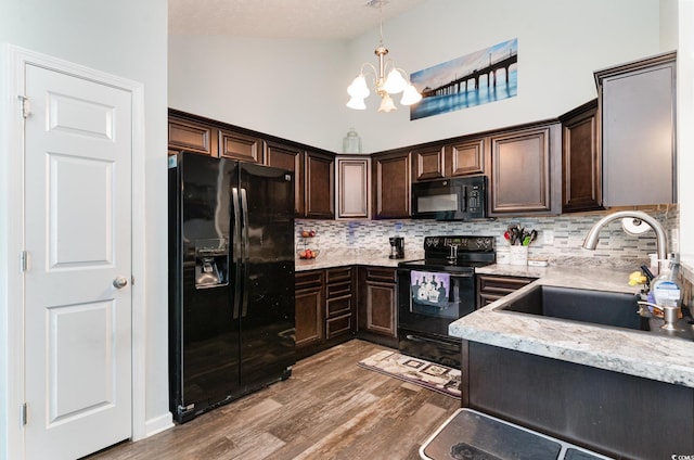 kitchen featuring black appliances, a notable chandelier, dark brown cabinetry, and sink