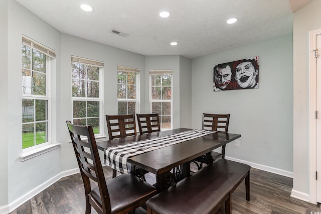 dining room with a textured ceiling and dark hardwood / wood-style floors