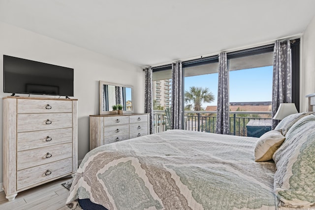 bedroom with access to exterior and light hardwood / wood-style floors