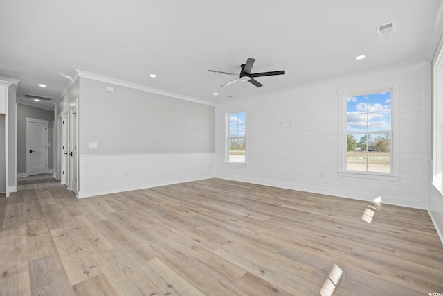 unfurnished room with light wood-type flooring, ceiling fan, crown molding, and wooden walls