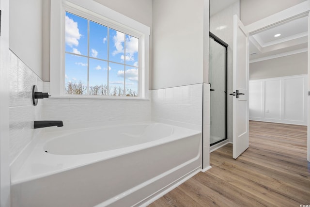 bathroom featuring shower with separate bathtub, ornamental molding, and wood-type flooring