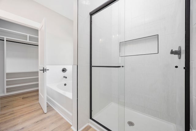 bathroom featuring hardwood / wood-style floors and independent shower and bath