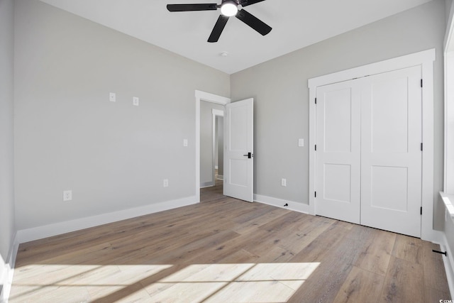 unfurnished bedroom with ceiling fan, light hardwood / wood-style floors, and a closet