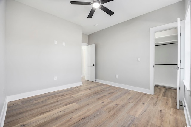 unfurnished bedroom with ceiling fan, light wood-type flooring, and a closet