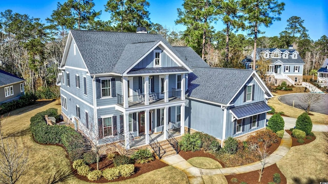 view of front of house with a balcony, a porch, and a front yard