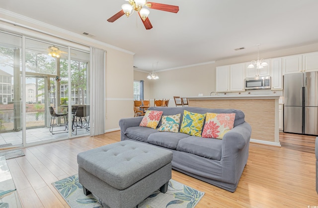 living room featuring ornamental molding, ceiling fan with notable chandelier, and light hardwood / wood-style floors