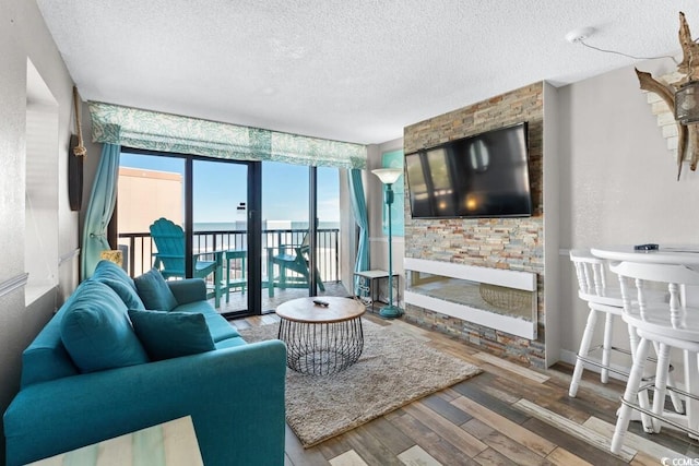 living room with hardwood / wood-style floors, expansive windows, and a textured ceiling