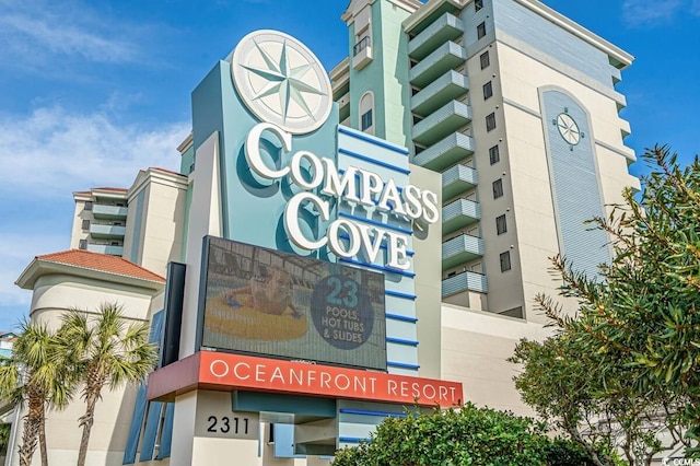 view of building exterior with a beach view and a water view