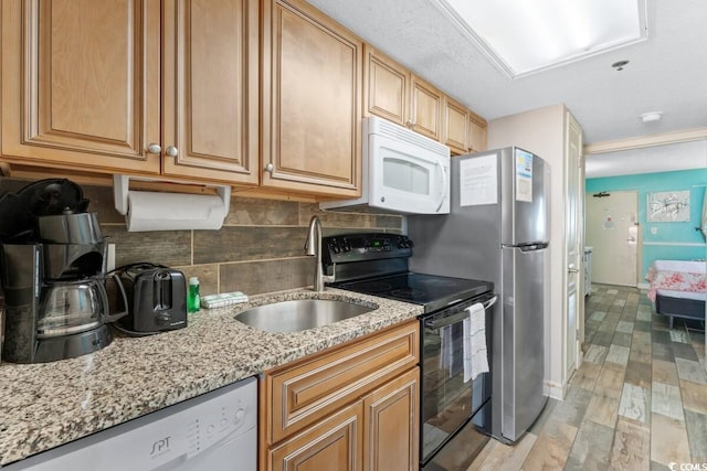 kitchen featuring dishwasher, sink, light hardwood / wood-style flooring, black electric range, and light stone counters