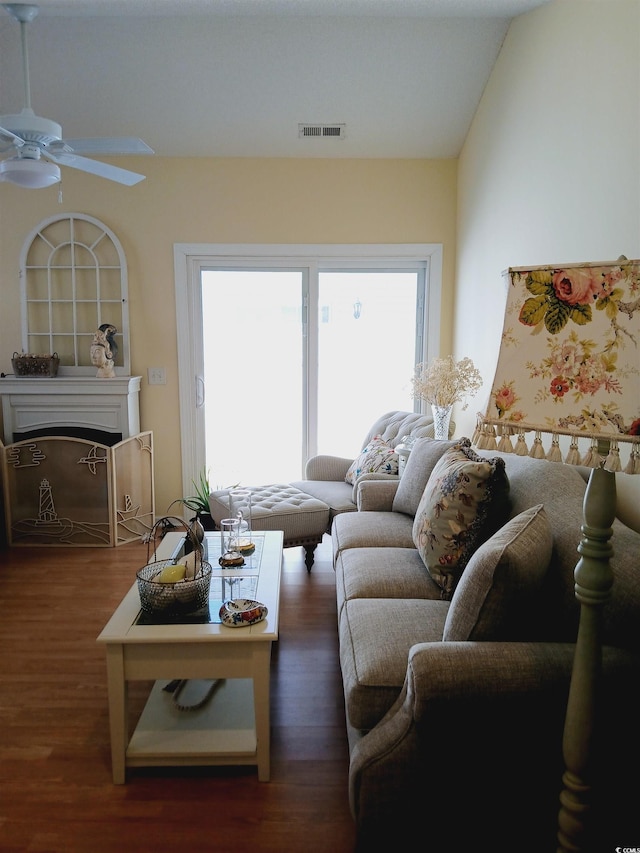 living room with lofted ceiling, ceiling fan, and dark wood-type flooring