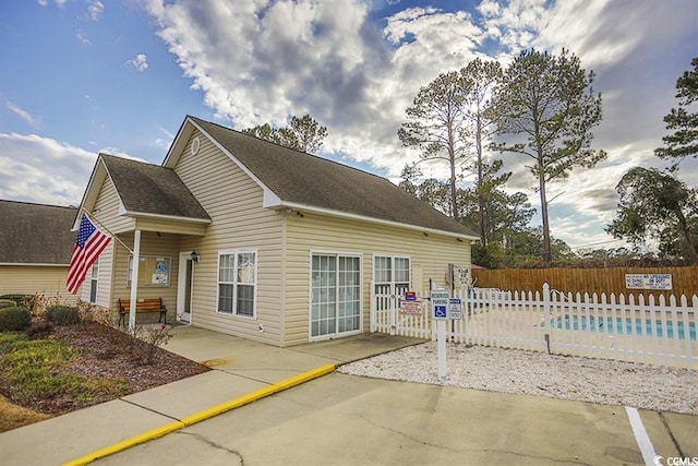 view of property exterior with a patio and a community pool