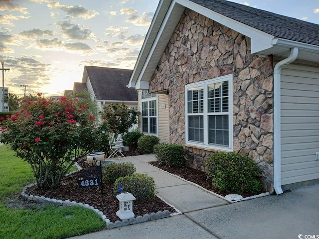 property exterior at dusk featuring a patio