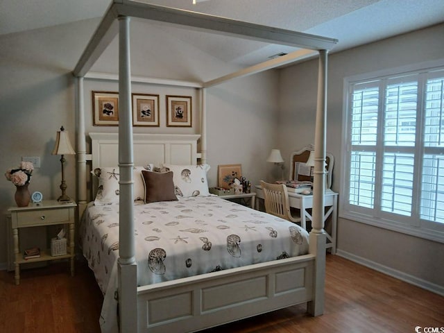 bedroom with lofted ceiling and dark hardwood / wood-style floors