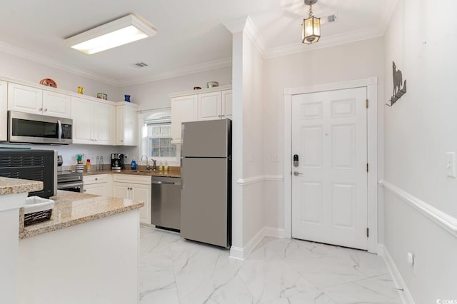 kitchen featuring white cabinetry, light stone counters, crown molding, and appliances with stainless steel finishes