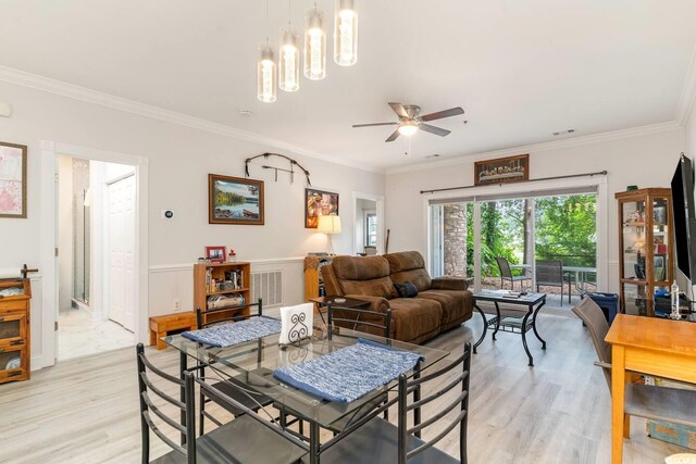 living room with ceiling fan with notable chandelier, light hardwood / wood-style flooring, and ornamental molding