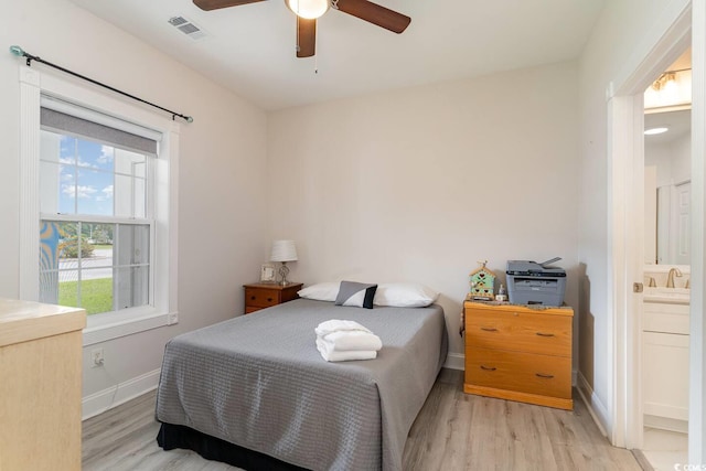 bedroom with light hardwood / wood-style flooring, ceiling fan, and ensuite bathroom