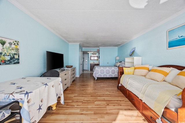 bedroom featuring ornamental molding and light wood-type flooring