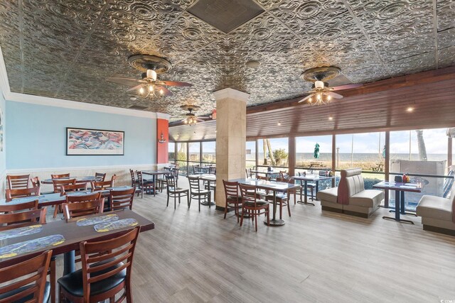 dining space with floor to ceiling windows, hardwood / wood-style flooring, and ceiling fan