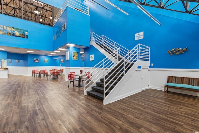 stairway featuring a high ceiling and wood-type flooring