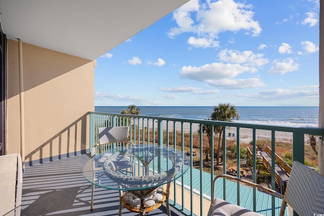 balcony featuring a view of the beach and a water view