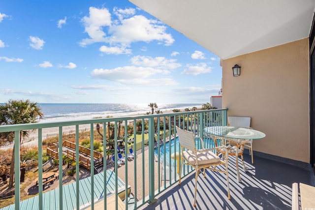 balcony featuring a view of the beach and a water view