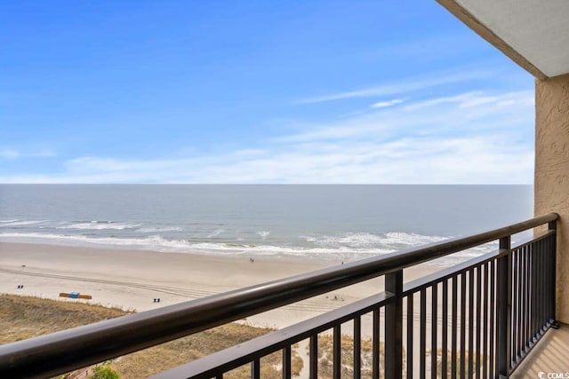 balcony featuring a water view and a beach view