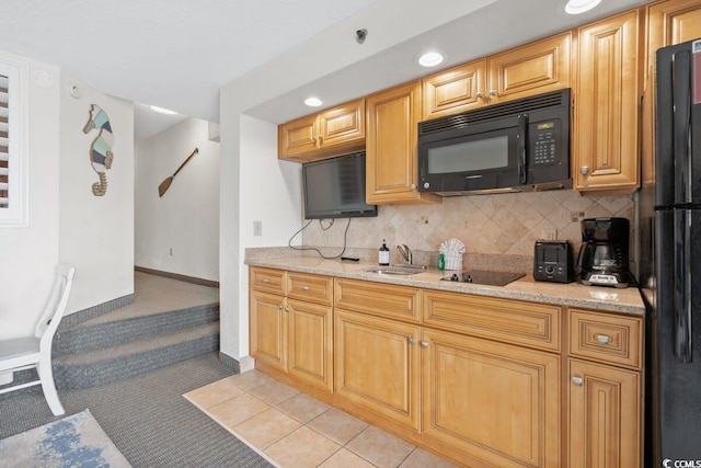 kitchen with black appliances, sink, light tile patterned floors, tasteful backsplash, and light stone counters