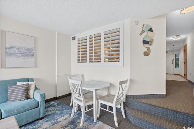 4800 S Ocean Blvd Unit 1219, North Myrtle Beach, SC 29582 - carpeted dining area featuring baseboards and a textured ceiling