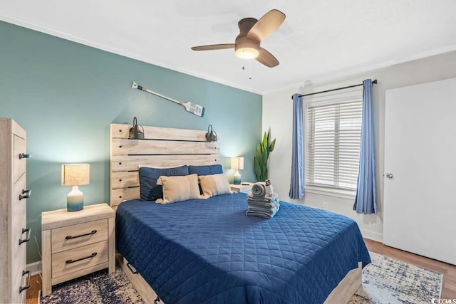 bedroom featuring ceiling fan, crown molding, and wood-type flooring