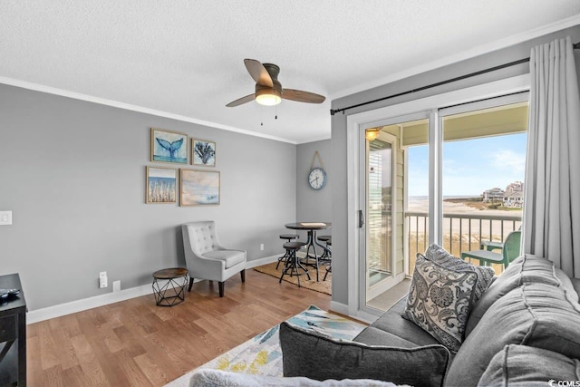 9400 Shore Dr Unit 312, Myrtle Beach, SC 29572 - living room featuring wood finished floors, a textured ceiling, ceiling fan, baseboards, and ornamental molding