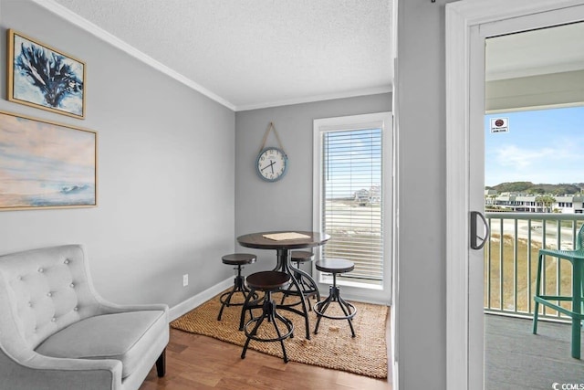 dining room featuring hardwood / wood-style floors, a textured ceiling, and ornamental molding