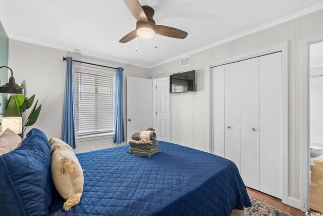 bedroom featuring ensuite bath, ceiling fan, wood-type flooring, a closet, and ornamental molding