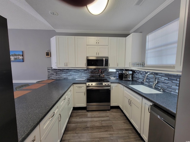 kitchen with white cabinets, sink, appliances with stainless steel finishes, tasteful backsplash, and dark hardwood / wood-style flooring